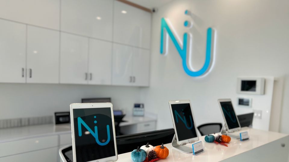 Nu Dentistry reception desk with branded check-in tablets and fall decorations