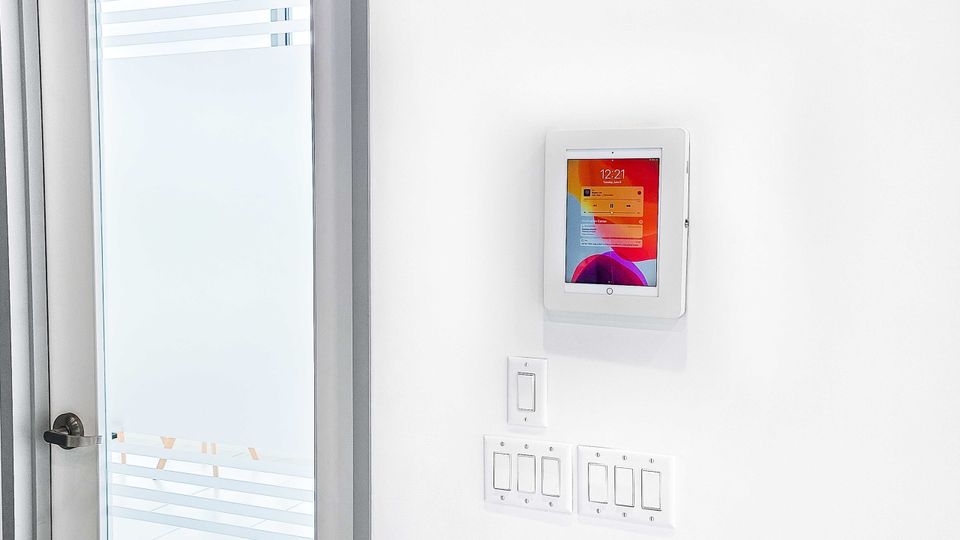 A tablet embedded in the wall beside the door.